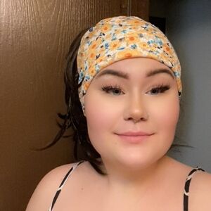 Comfy Floral Headband with Orange and Blue Accenta with Black Ponytail Attached.